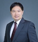 一位身著深色西裝、白色襯衫和栗色領帶的男士，在素雅的灰色背景下，擺出專業的頭像。.