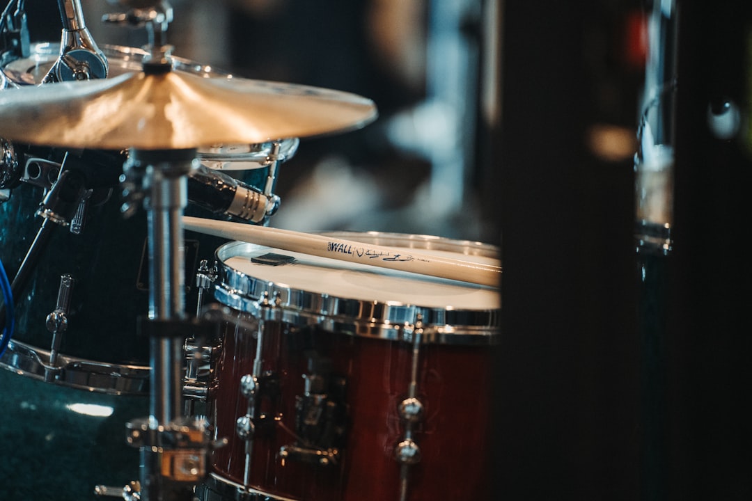 一套鼓組的特寫鏡頭,一對鼓棒擱在小軍鼓上,前景中可見一枚鈸。. Photo drum tutorial videos