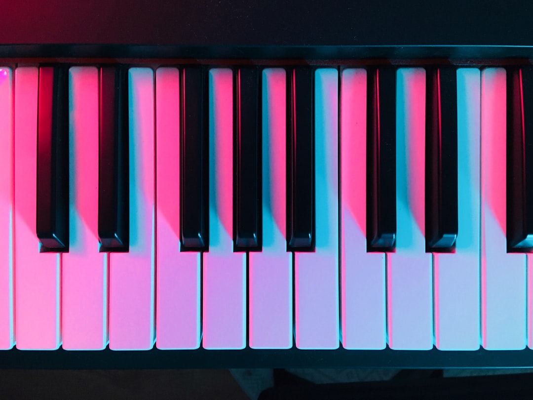 被粉紅色和藍色燈光照亮的鋼琴鍵特寫。. Photo piano music